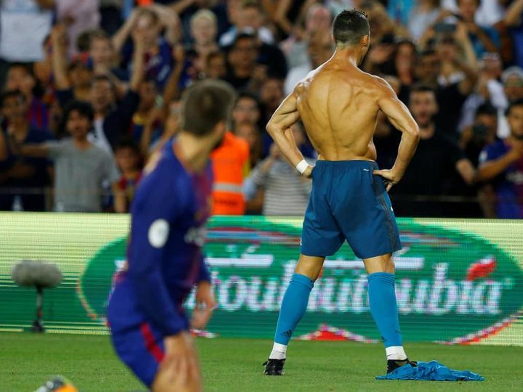 Cristiano Ronaldo scores against Barcelona as Gerald Pique looks on. 